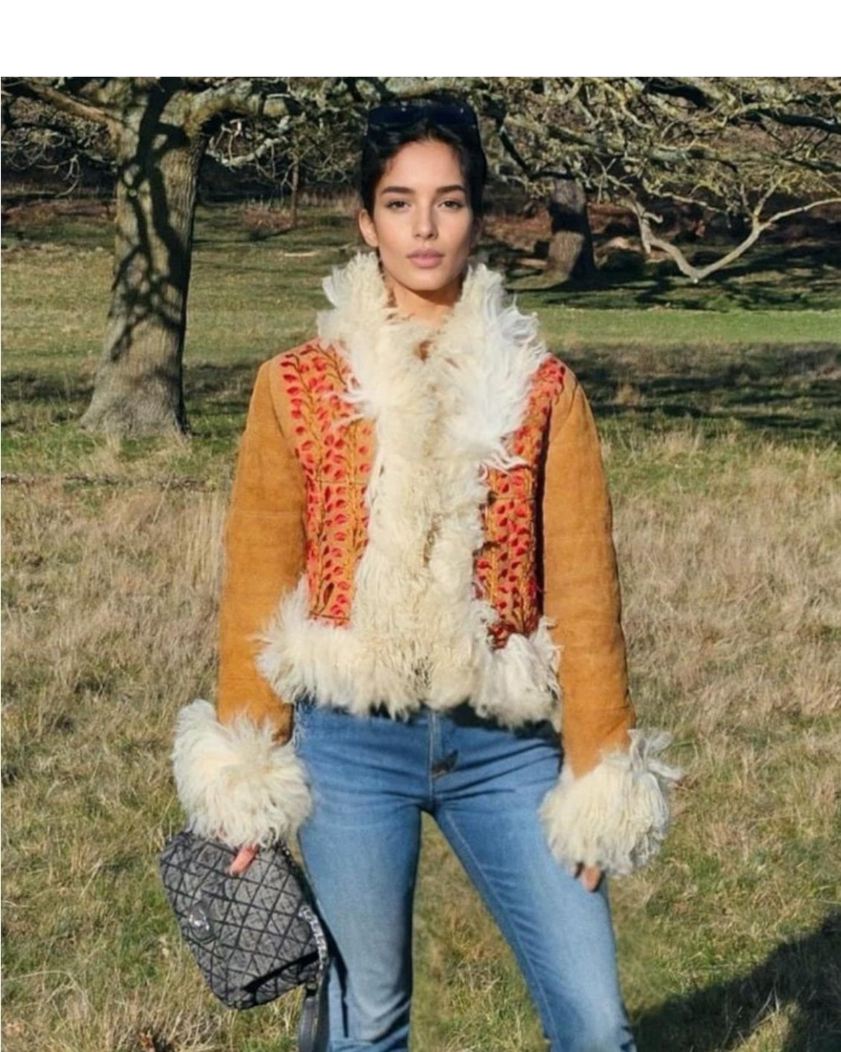 Aql&Nafs Tara Jacke aus braunem Leder mit Pelzbesatz und roter Stickerei, getragen von einem Model im Freien.