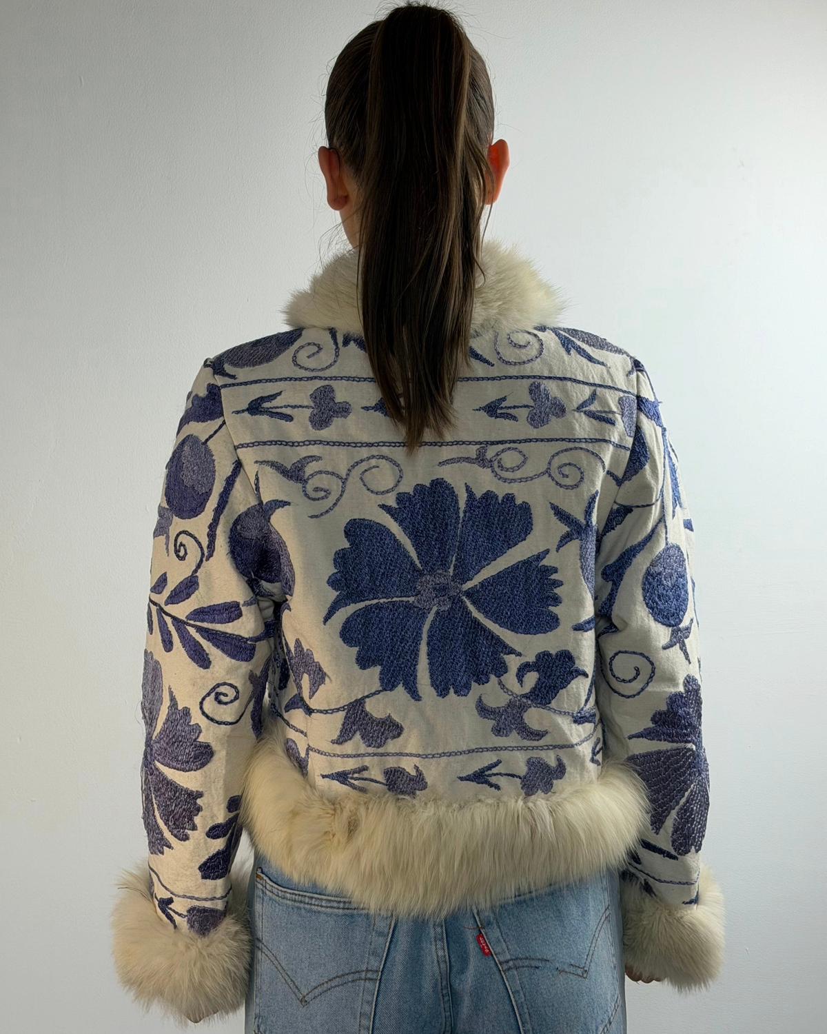 Aql&Nafs Bahar Suzani Jacke mit blauer Blumenstickerei, elfenbeinfarbenem Shearling-Besatz und handgefertigtem Design.