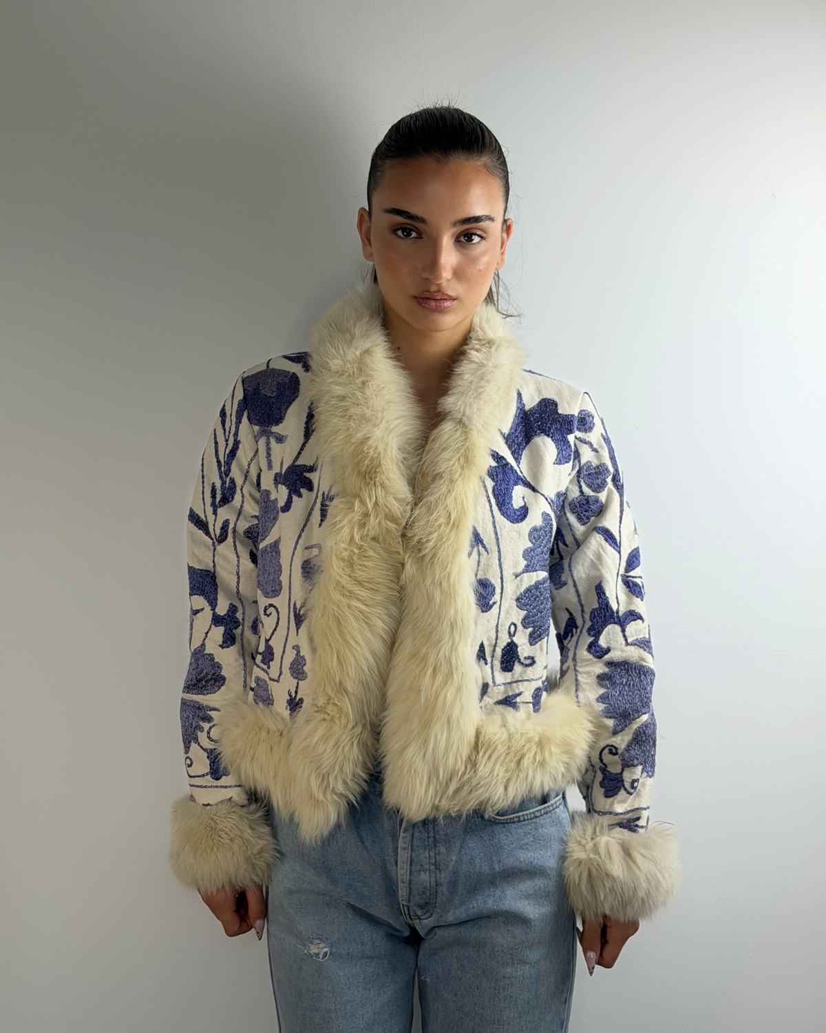 Aql&Nafs handbestickte Bahar Suzani Jacke mit blauem Blumenmuster, cremefarbenem Lammfellbesatz und weichem Futter.