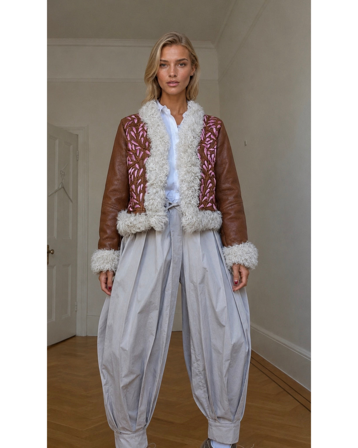 Aql&Nafs Amal Jacke aus braunem Leder mit rosa Stickerei und weißem Fellbesatz an einem Model
