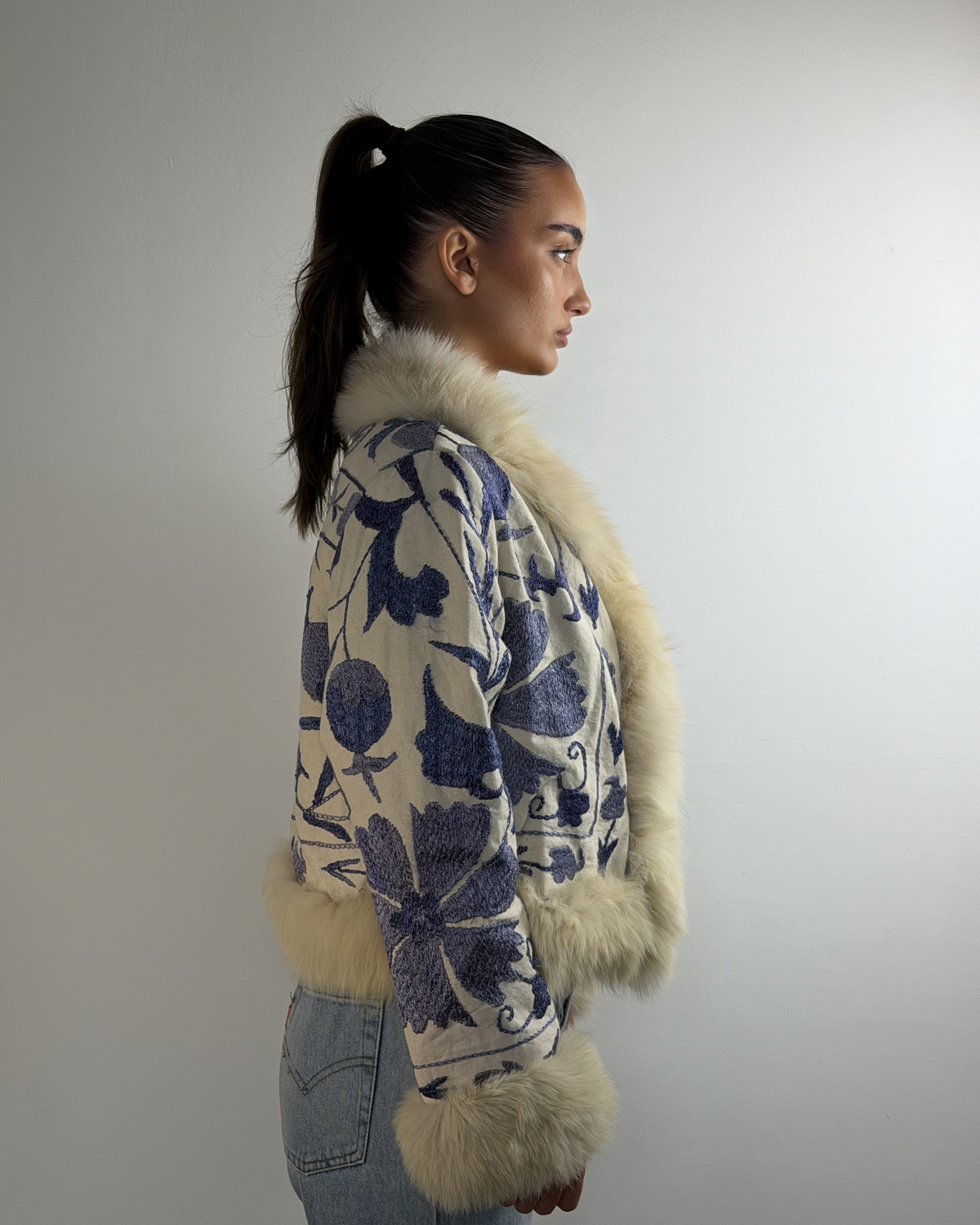 Aql&Nafs handbestickte Bahar Suzani Jacke mit blauem Blumenmuster, beigem Lammfellbesatz und entspannter Passform.